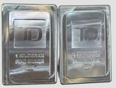 Two 1-kilogram fine silver bars with TD logo on a white background