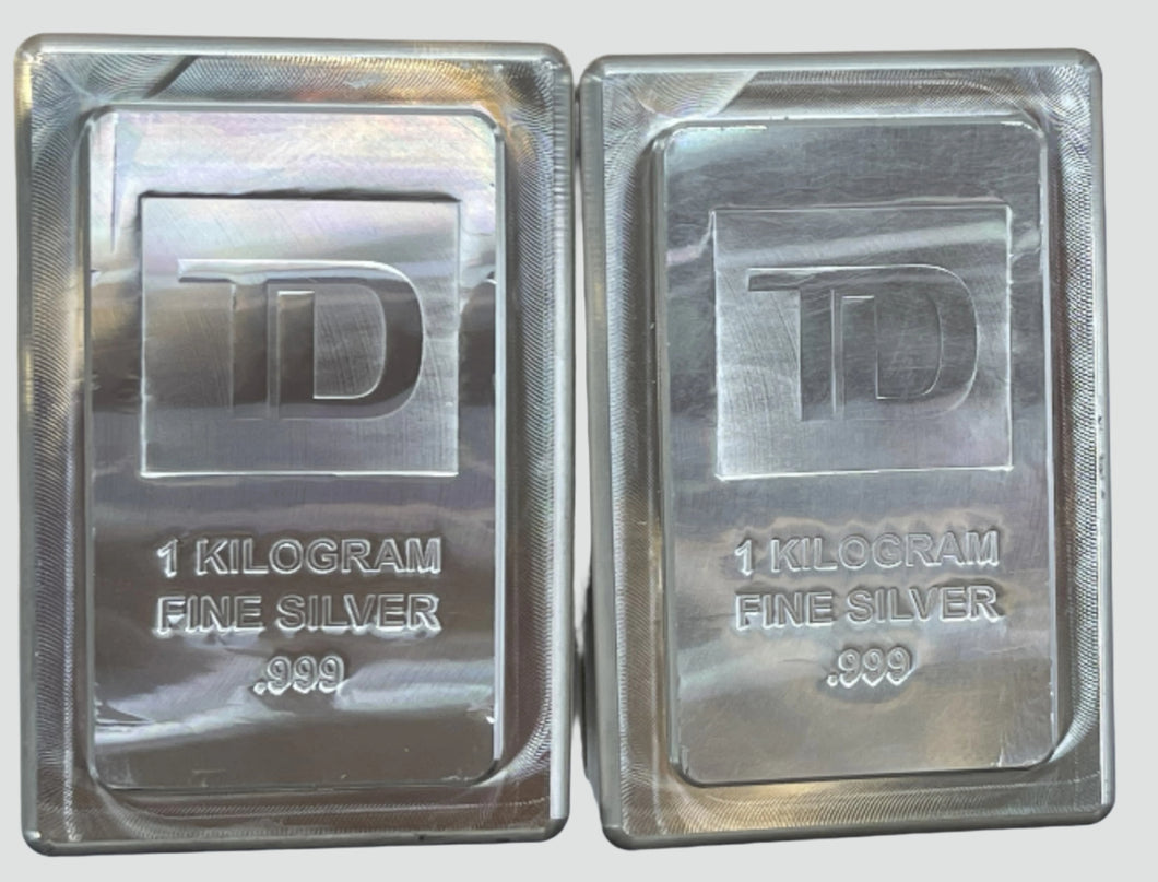 Two 1-kilogram fine silver bars with TD logo on a white background